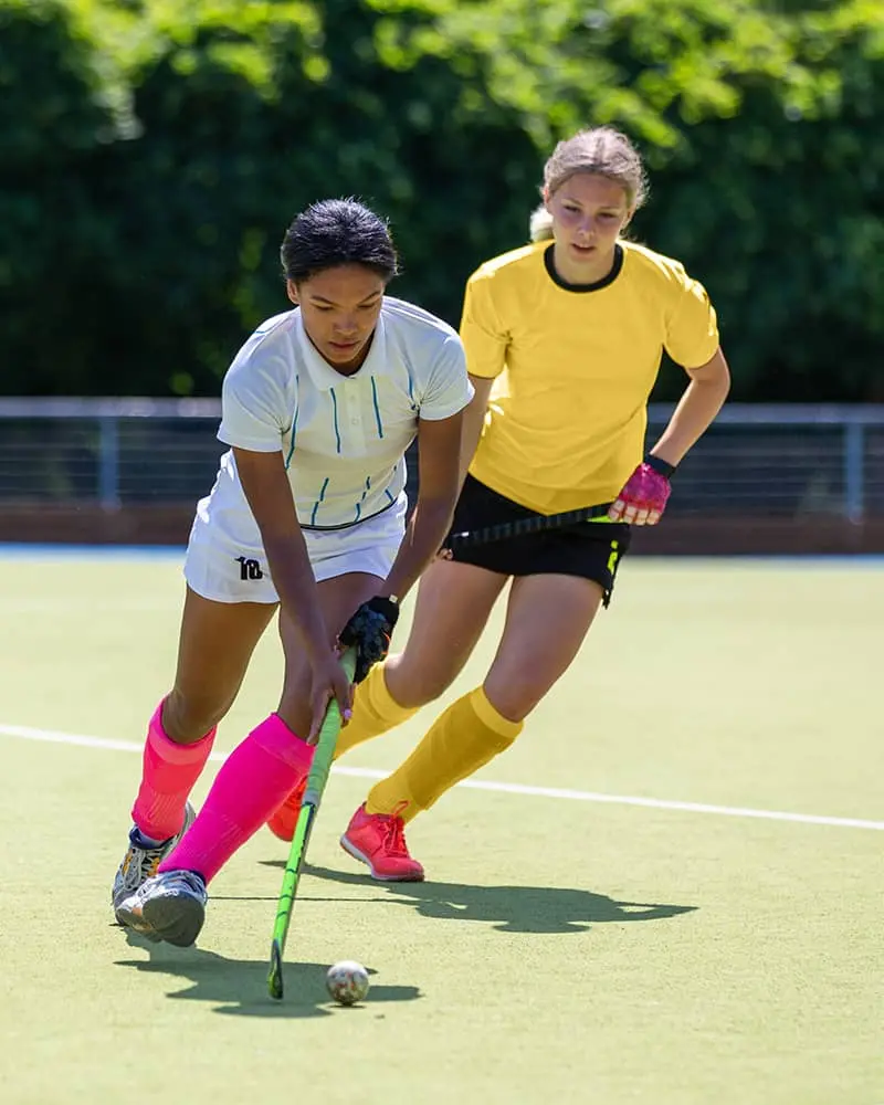 Two young women playing hockey