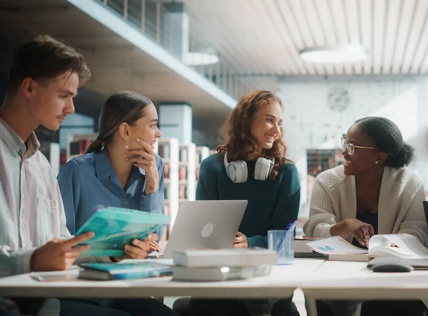 Three women and a man conversing at a table