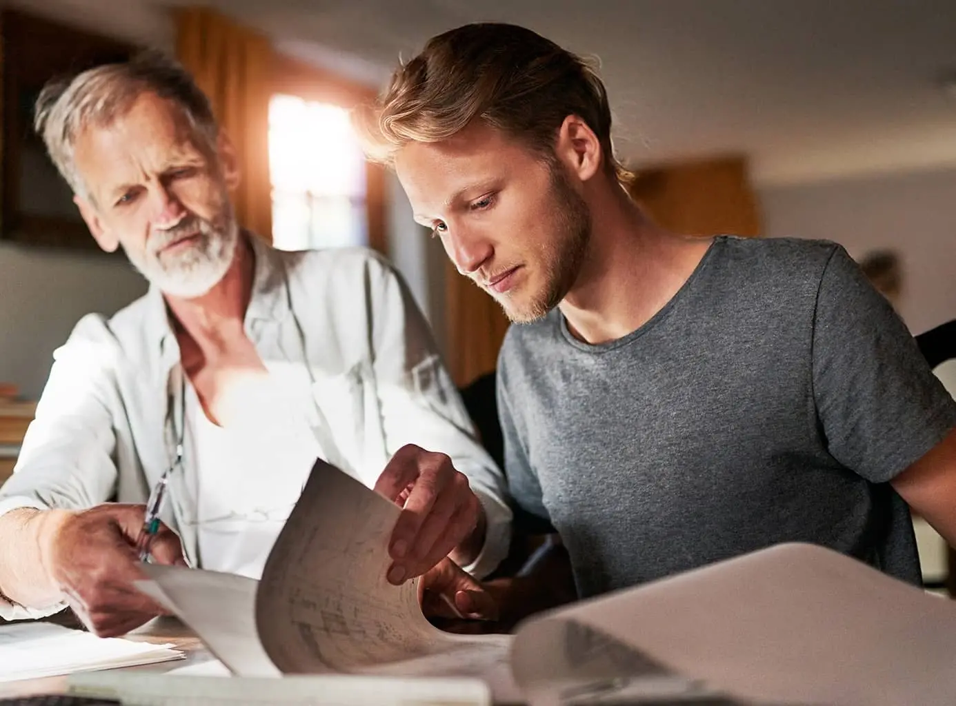 Two men read through documents together